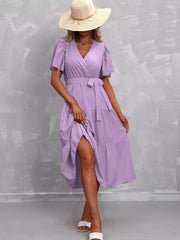 Lavender tiered midi dress with flutter sleeves, V-neck, and belted waist.