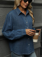 Navy denim shirt with puffed sleeves, collared, buttoned front, and vertical pleats.