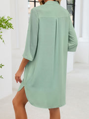 Light green button-down shirt dress with band collar and side slits.