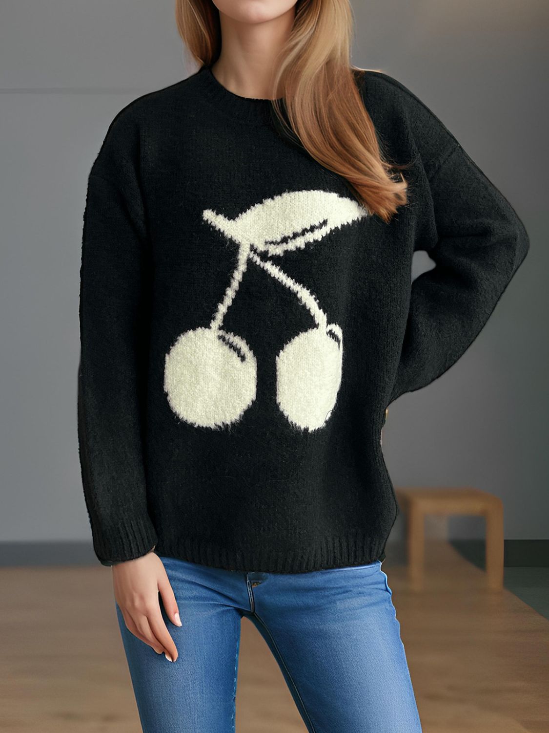 Black knit sweater with a white cherry motif, crew neck, long sleeves, and ribbed cuffs and hem.
