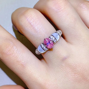 Pink oval moissanite and mother-of-pearl ring with diamond accents on a silver band.