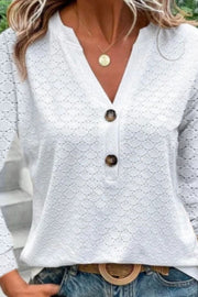 White lace-effect henley blouse with decorative buttons and V-neck.