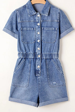 Medium wash denim romper with short sleeves, button-down front, elastic waist, and cuffed shorts.
