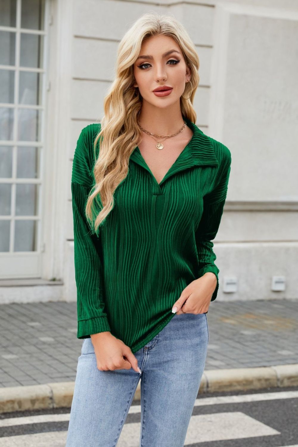 Dark green collared blouse with wave-effect pleats and long sleeves.
