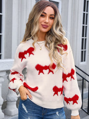 Cream knit pullover sweater with red bow motif, crew neck, long sleeves.