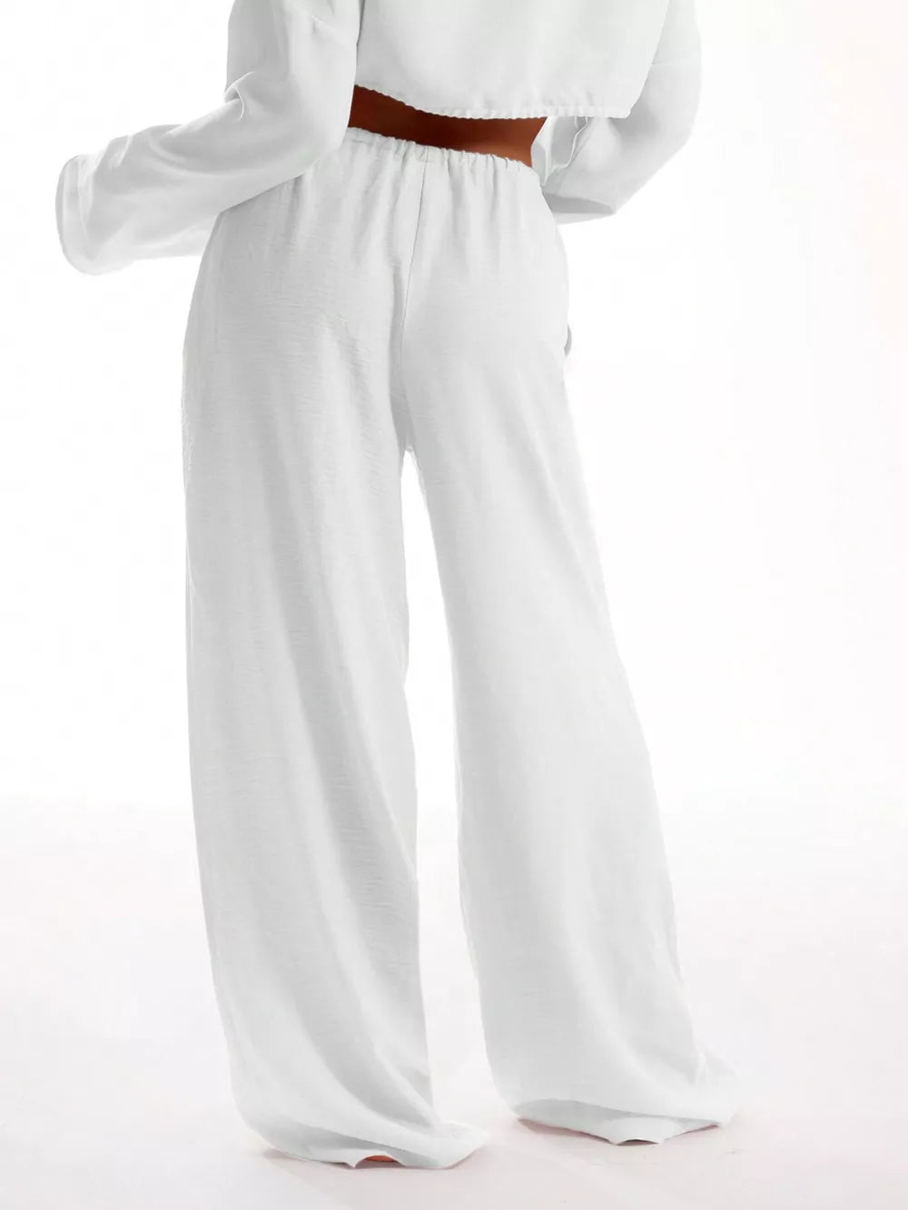 White relaxed wide-leg maternity pants with drawstring waist and textured fabric.