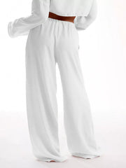 White relaxed wide-leg maternity pants with drawstring waist and textured fabric.