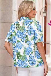 White blouse with blue hydrangea floral print, short puff sleeves, and smocked neckline.