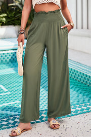 Matcha green smocked waist palazzo trousers with wide legs and pockets.