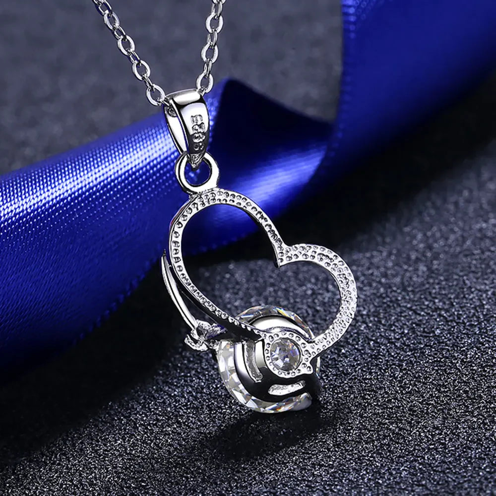 Silver heart halo pendant necklace with a clear crystal accent.