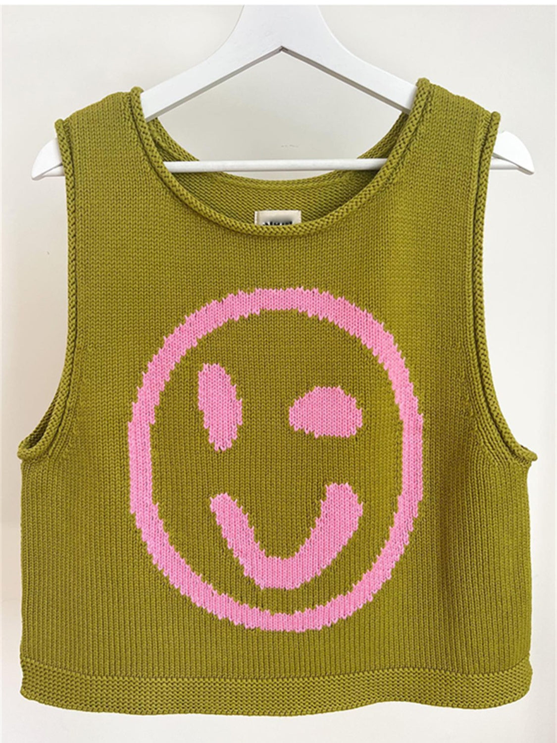 Olive knit tank top with pink smiley face graphic.