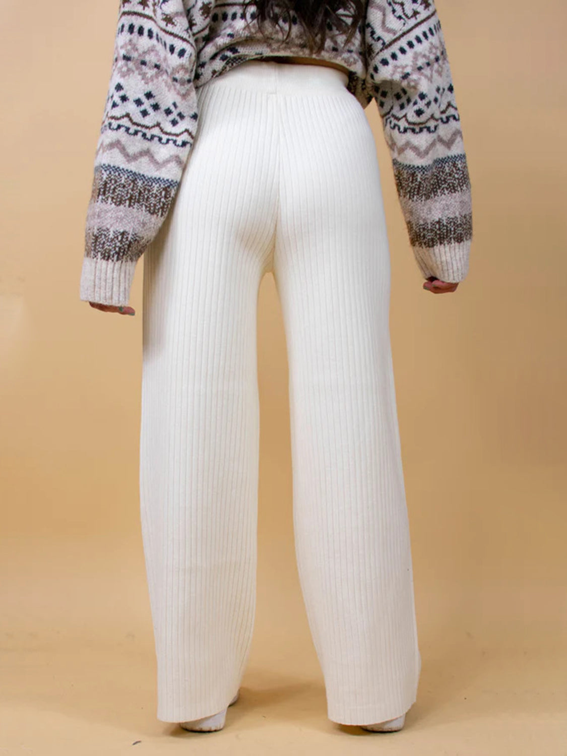 White ribbed knit palazzo trousers with a wide leg, shown from the back.