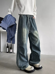 Relaxed fit blue denim cargo jeans with drawstring waist and distressed wash.