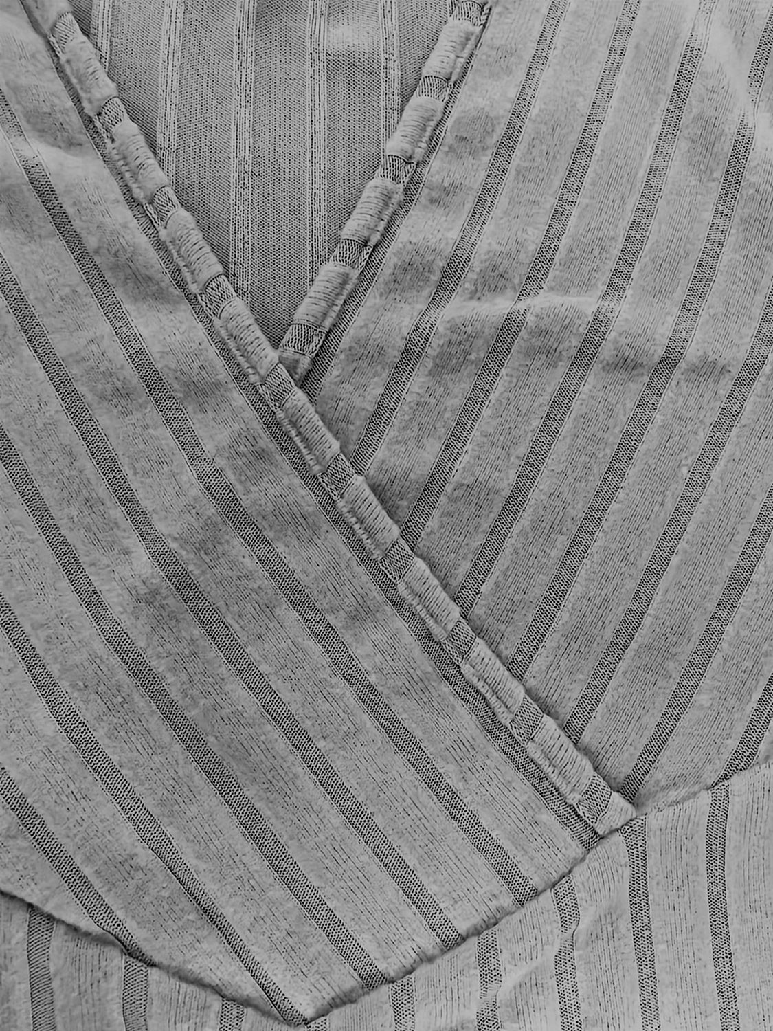 Gray ribbed wrap top with plunging neckline and vertical stripe detail.