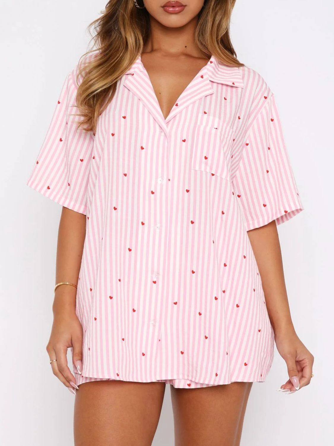 Blush pink striped pajama set with red heart print, collared button-up top and shorts.