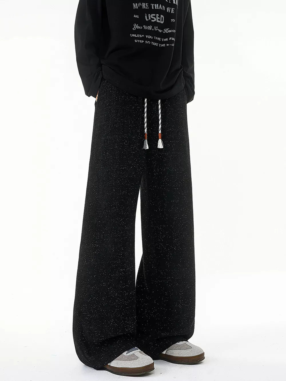Black textured knit sweatpants with white drawstring and wide leg