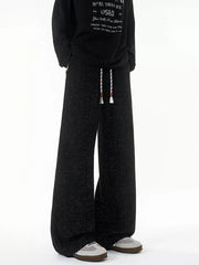Black textured knit sweatpants with white drawstring and wide leg