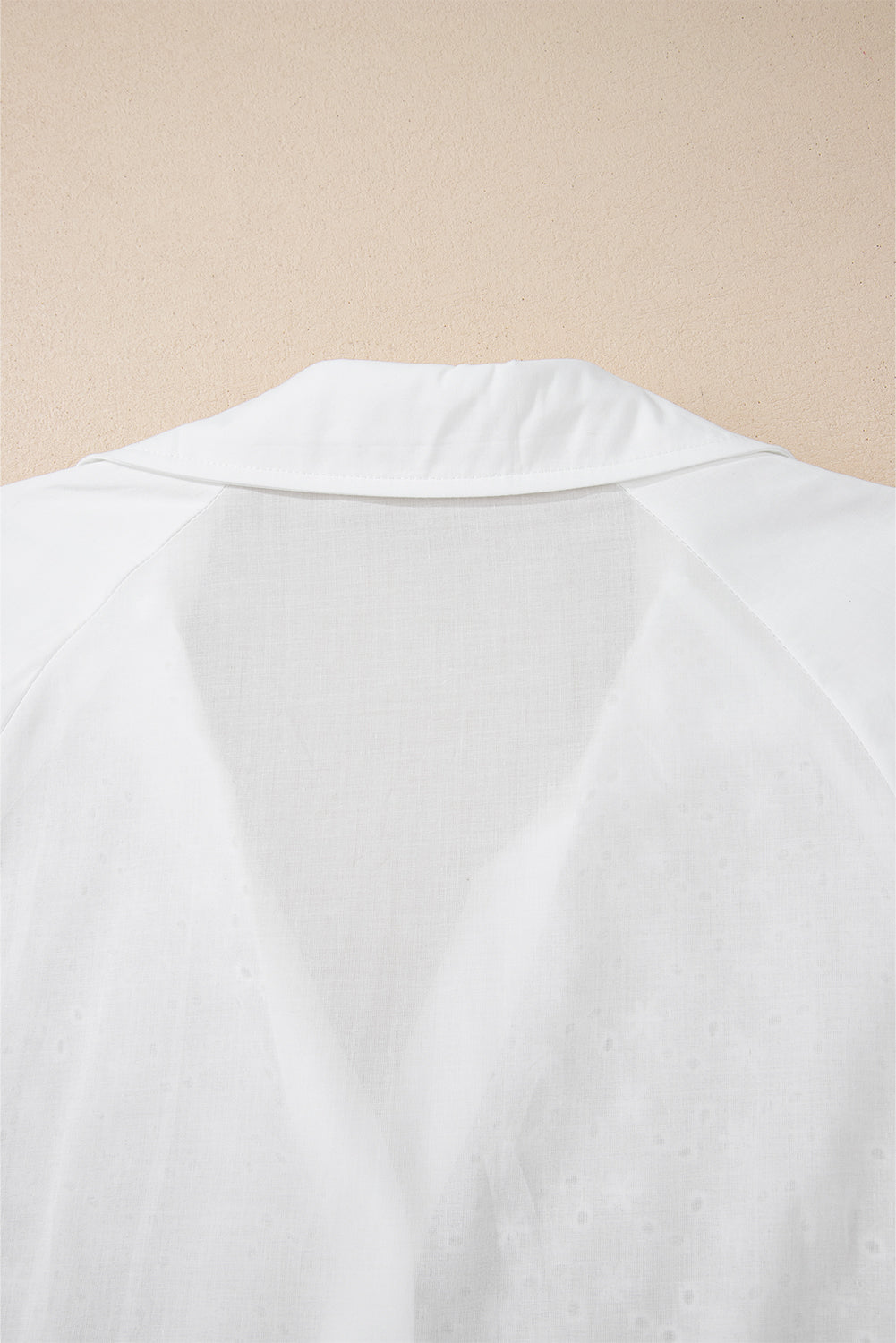 White embroidered eyelet blouse with a collared neckline and poet sleeves.
