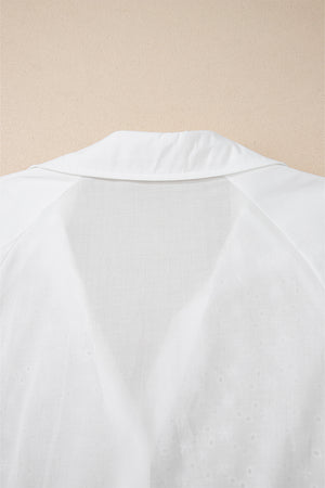 White embroidered eyelet blouse with a collared neckline and poet sleeves.