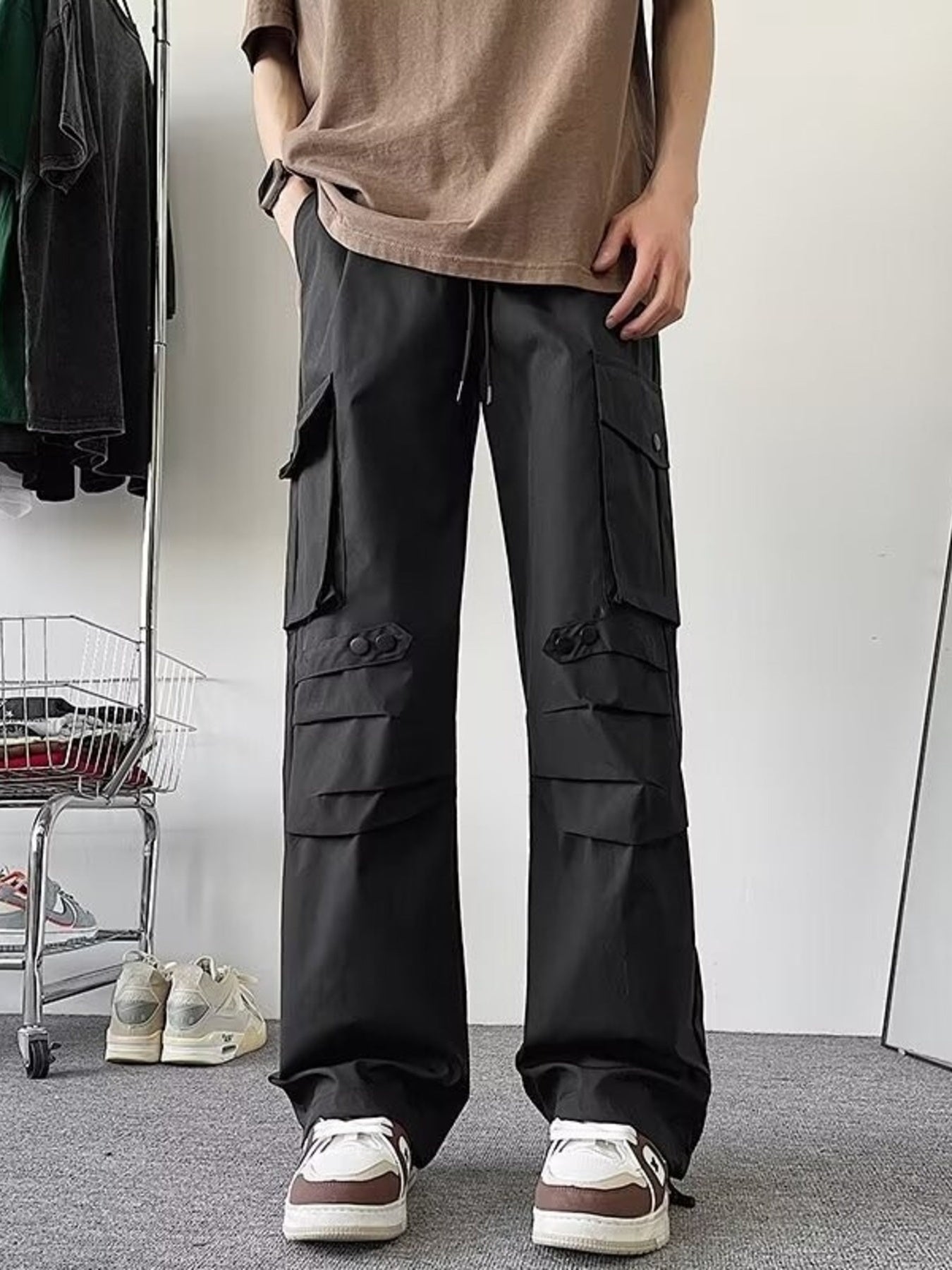 Black wide-leg cargo pants with multiple flap pockets and button details.