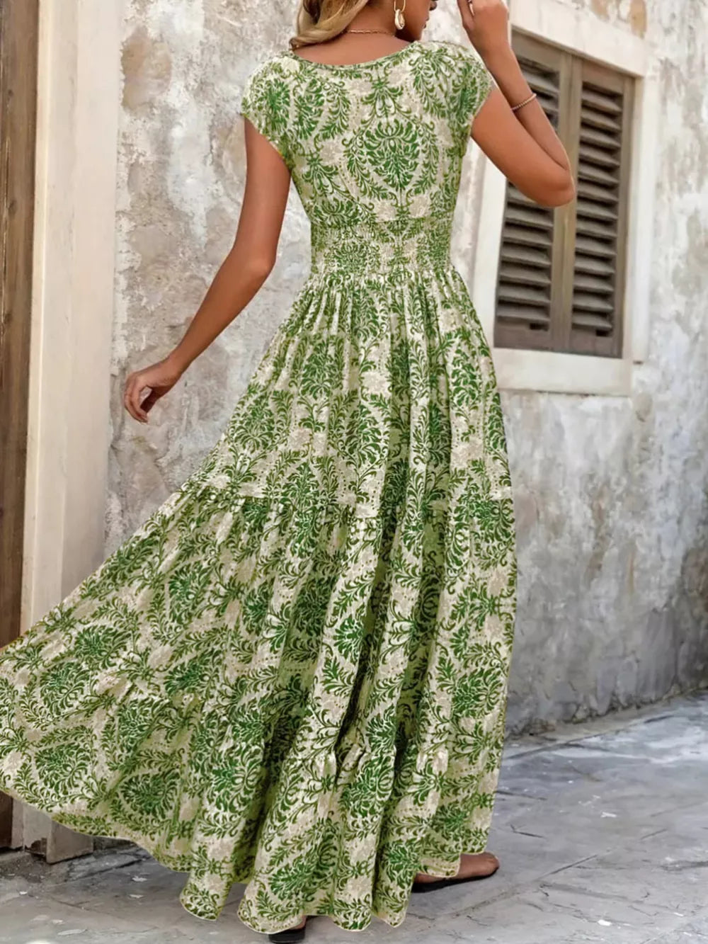 Maxi dress with smocked bodice, short sleeves, and tiered skirt in green floral print.
