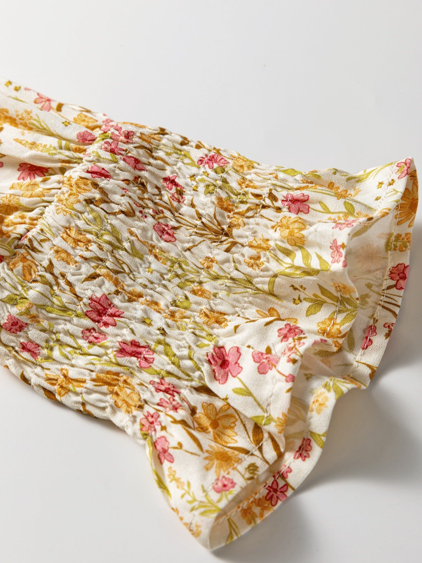 Floral print shirred sleeve dress with pink and yellow flowers on white fabric.