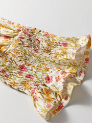 Floral print shirred sleeve dress with pink and yellow flowers on white fabric.