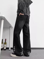 Black wide-leg men's jeans with star embroidery on the hems.