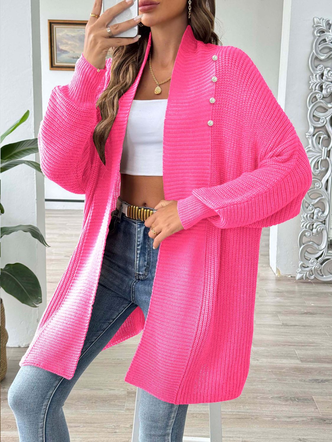 Pearl button ribbed knit cardigan in strawberry pink with a relaxed fit and open front.