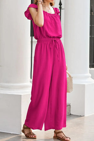 Hot Pink textured jumpsuit with ruffle sleeves, drawstring waist, and palazzo pants.