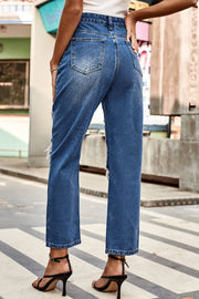 Distressed straight leg denim jeans in medium wash with ripped details.