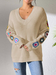 Tan v-neck sweater with colorful crochet granny square details on the sleeves.