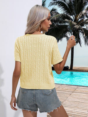 Light yellow cable knit crew neck short sleeve sweater with textured knit pattern.