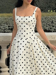 White A-line maxi dress with black polka dots, square neckline, and spaghetti straps.
