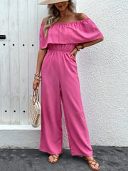Hot pink off-the-shoulder ruffled waist jumpsuit with wide legs.