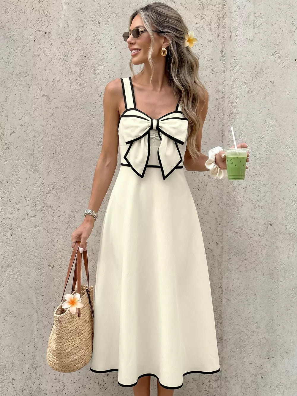 Elegant A-line midi dress in beige with black trim and a large bow detail on the bust.