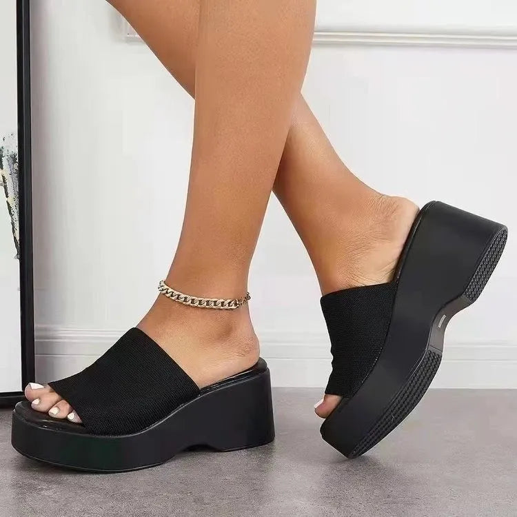 Black platform knit slide sandals with peep toe and chunky sole.