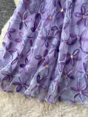 Purple layered skirt with embroidered floral appliques and sequins.