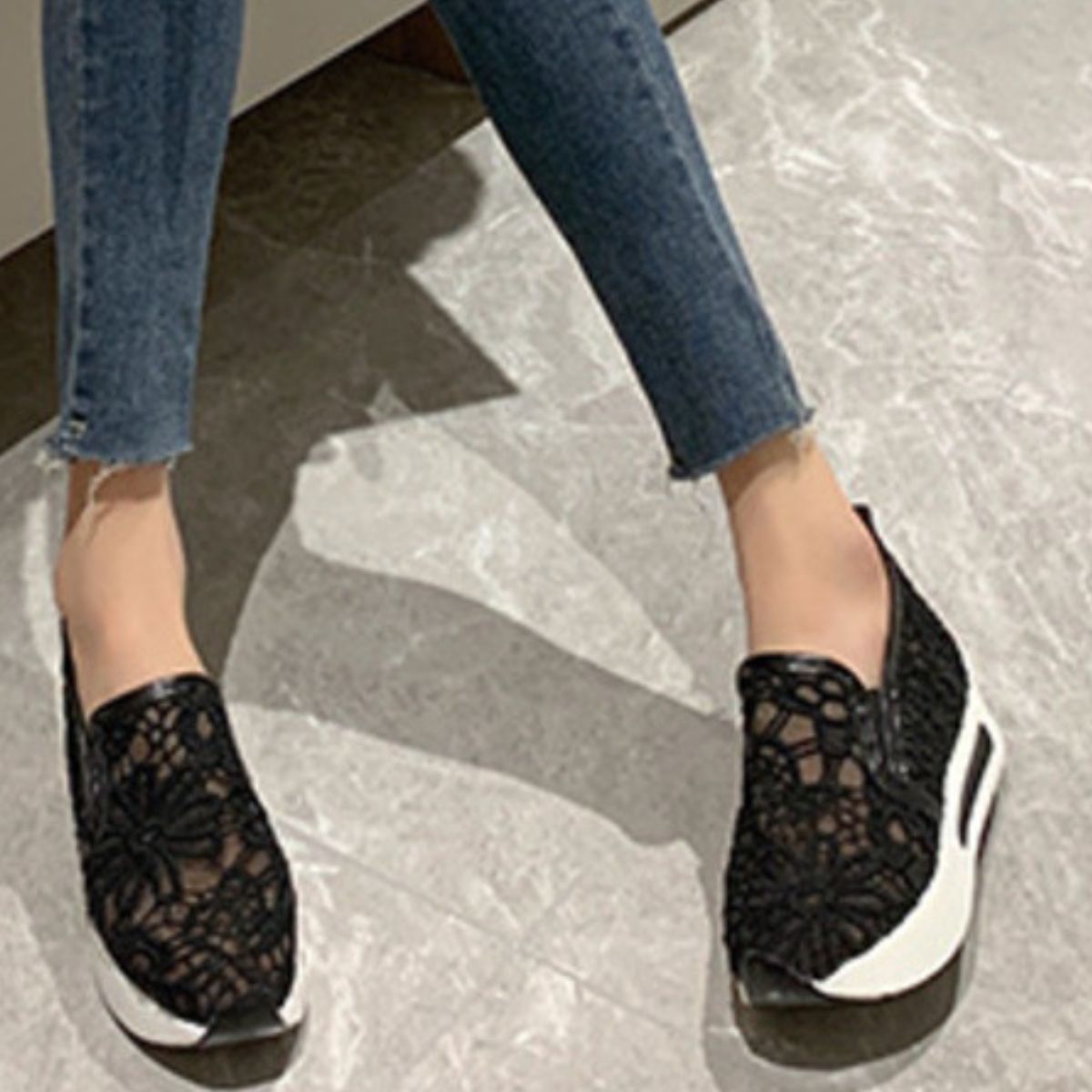 Black lace mesh slip-on flats with white soles.
