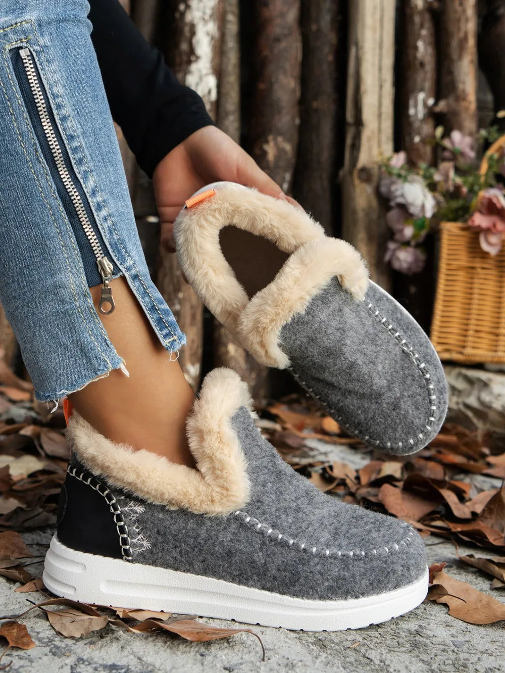 Gray felted slippers with faux fur lining and stitch detail.