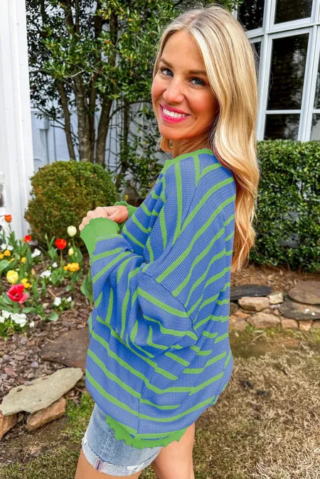 Waffle knit sweater with blue and green stripes and contrast green cuffs.