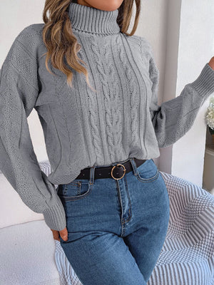 Light Gray cable knit turtleneck sweater with drop shoulder and textured sleeves.