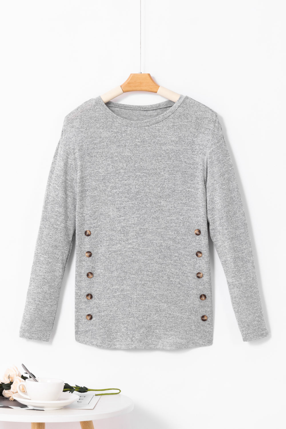 Dark gray slouchy knit top with side button details and long sleeves.