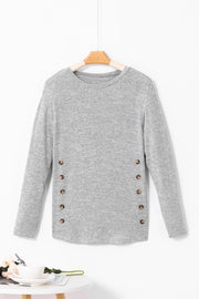 Dark gray slouchy knit top with side button details and long sleeves.