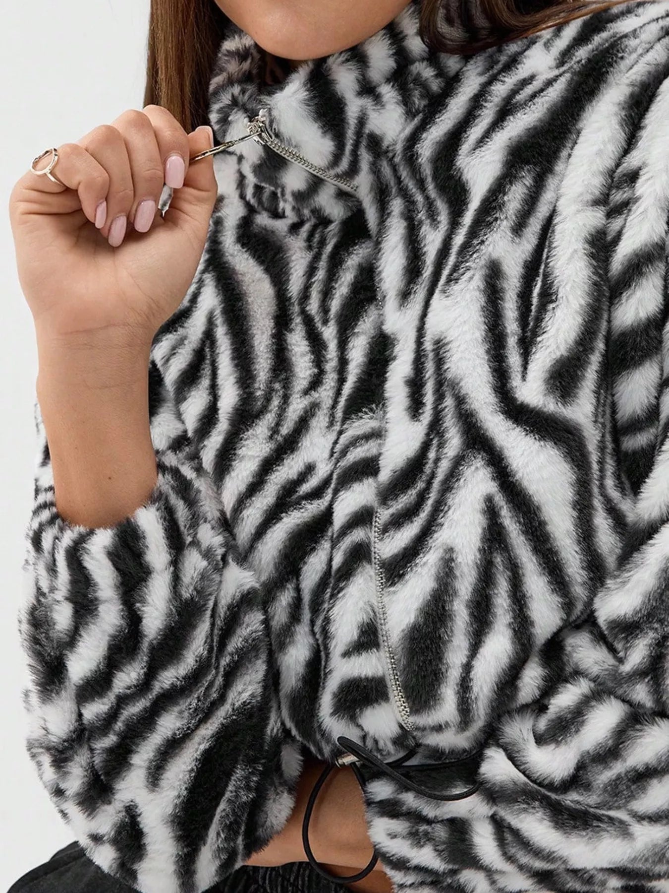 Plush cropped jacket with black and white zebra print, featuring a drawstring closure.