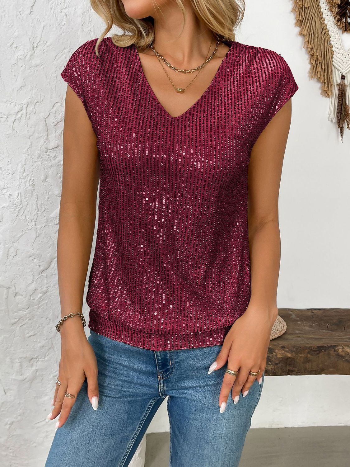 Crimson sequined cap-sleeve V-neck blouse with vertical stripe pattern.