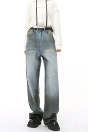 Pocketed high rise slouchy denim jeans in a medium wash with a dark gradient hem.