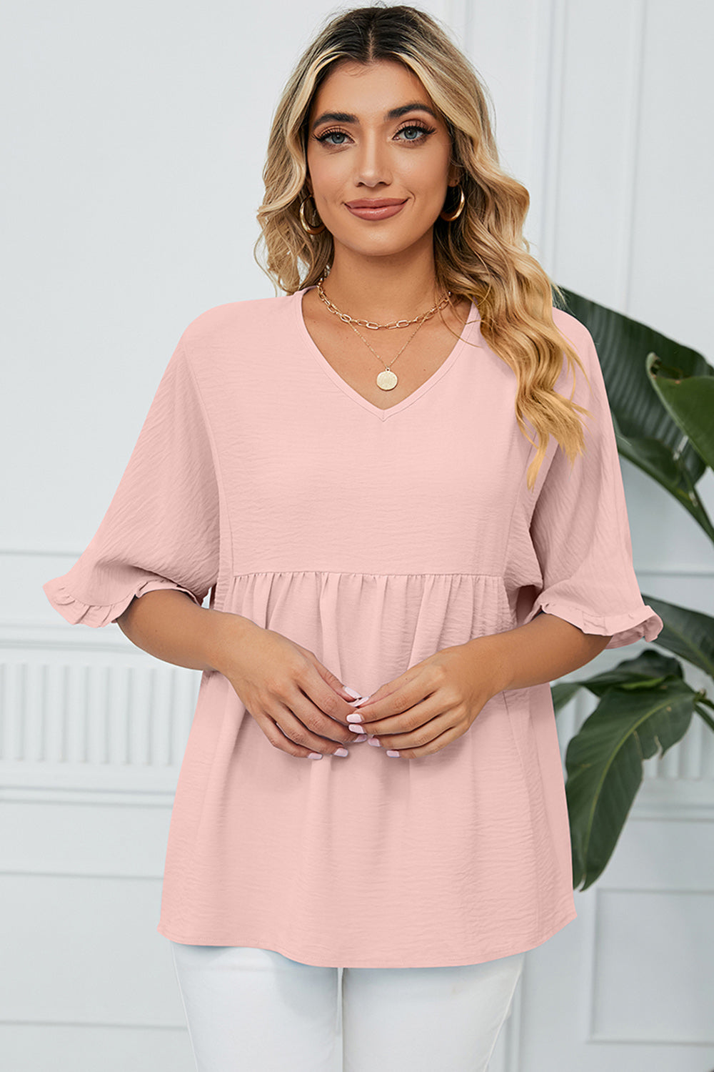 Gathered yoke flutter sleeve blouse in watermelon pink with v-neck and ruffled cuffs.
