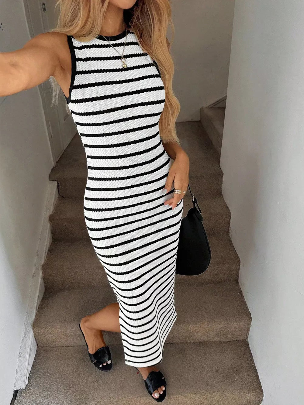 Sleek black and white striped bodycon midi dress with a round neckline and sleeveless design.