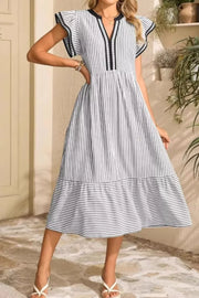 Striped midi dress with ruffle sleeves and tiered hem in black and white.